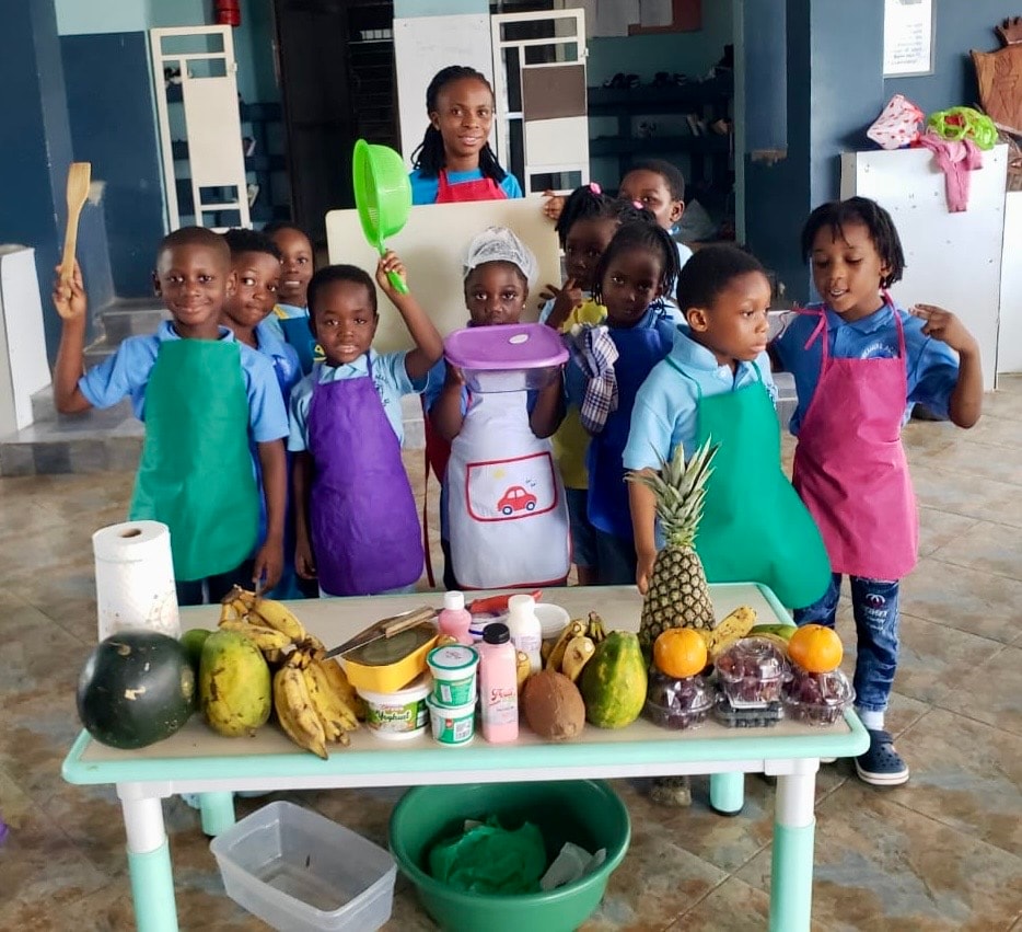 Children sitting in a row enjoying their smoothies